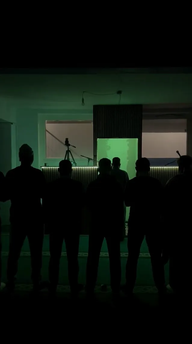 Individuals praying behind the imam at a mosque